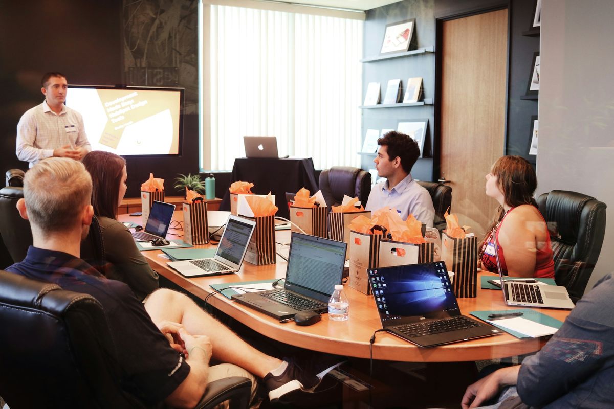 A hands-on corporate software training workshop with laptops and a presentation screen